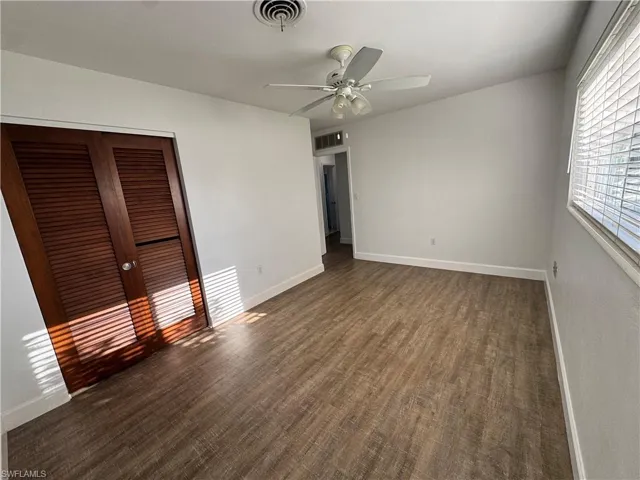Laundry area featuring a ceiling fan, a sink, dark wood-type flooring, baseboards, and separate washer and dryer