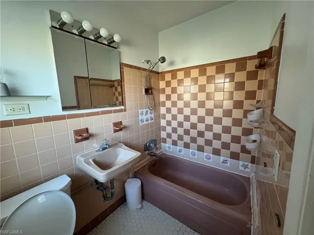 Spare room featuring baseboards, visible vents, ceiling fan, and dark wood finished floors