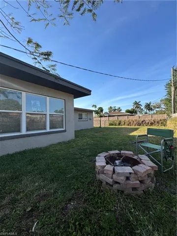 View of home's exterior featuring a lawn, stucco siding, and fence