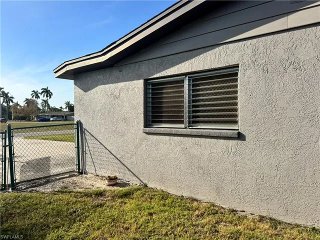 View of home's exterior with a lawn, central AC unit, fence, and stucco siding