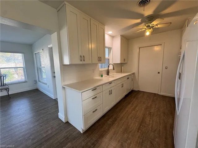 Corridor featuring baseboards and dark wood-style floors