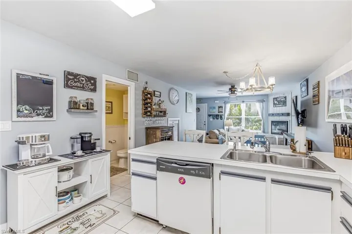 Kitchen with white cabinetry, a double basin sink, and a built-in dishwasher