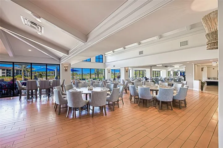 Dining space featuring beamed ceiling, a high ceiling, and light hardwood / wood-style floors