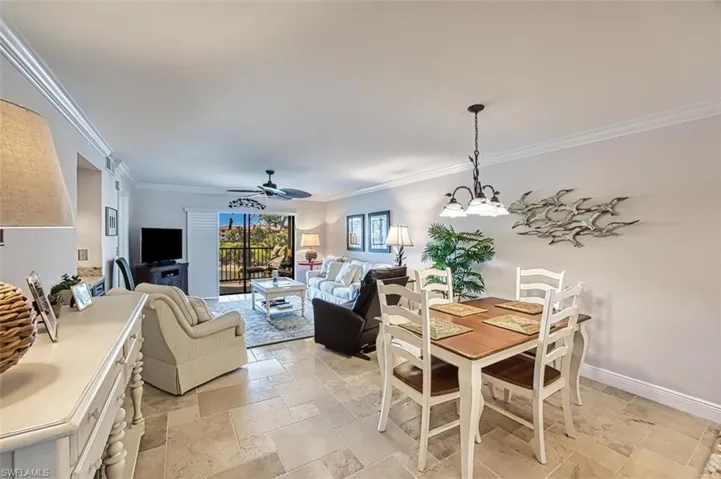 Dining space with ornamental molding and ceiling fan with notable chandelier