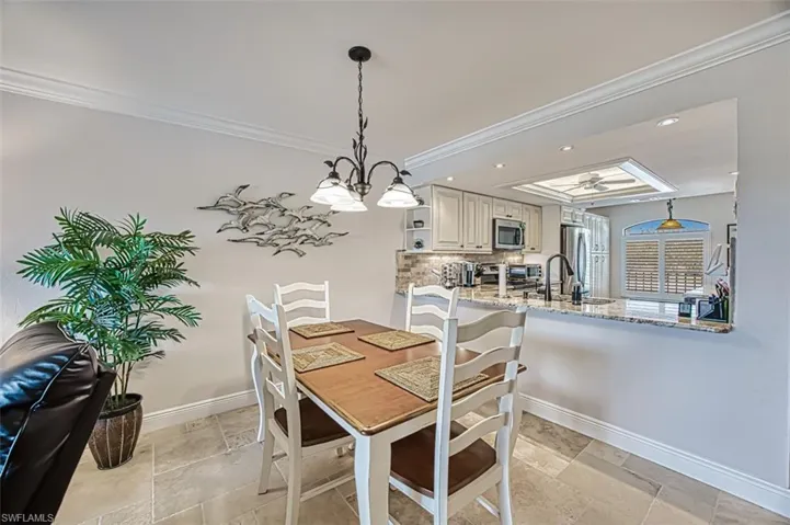 Dining space featuring ornamental molding and sink