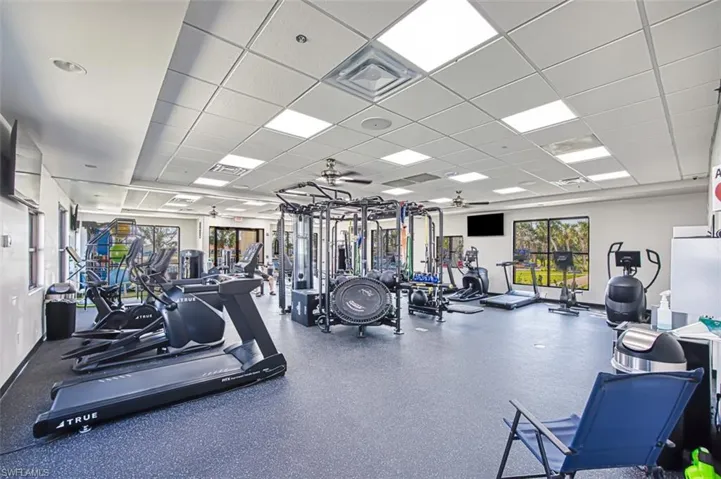 Workout area with ceiling fan and a paneled ceiling