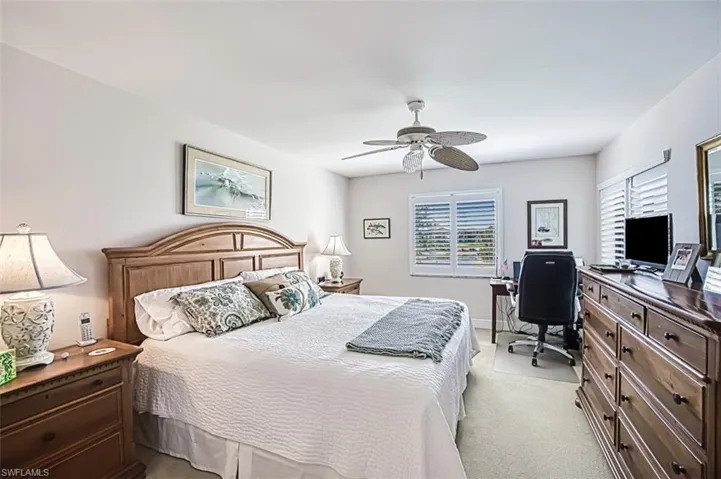 Carpeted bedroom featuring ceiling fan