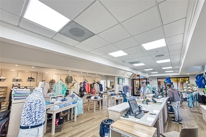 Exercise room with a drop ceiling and light hardwood / wood-style flooring