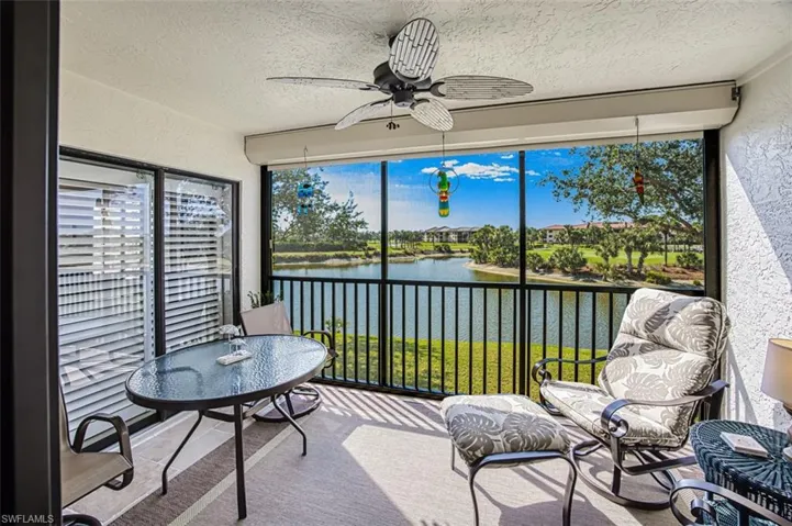Sunroom / solarium featuring a water view and ceiling fan