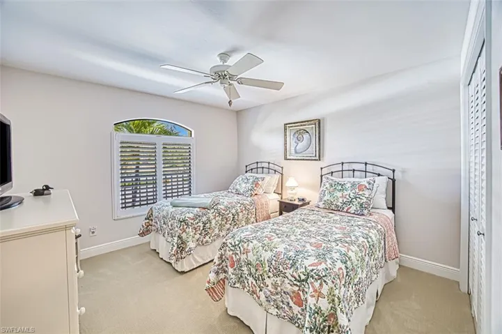 Bedroom with light colored carpet and ceiling fan