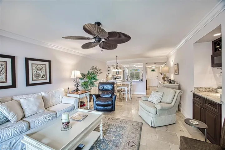 Living room featuring ornamental molding and ceiling fan