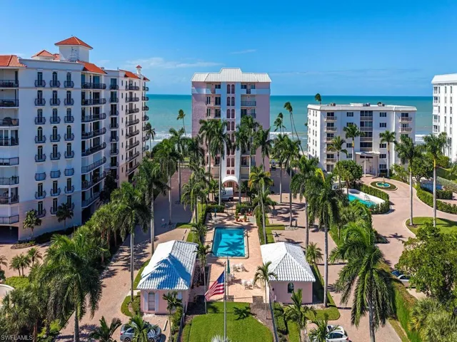 Drone / aerial view of a pool area and apartment complex / building