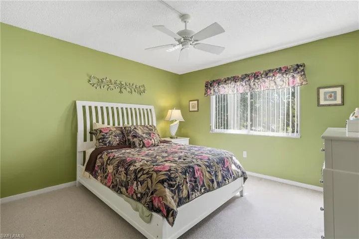 Bedroom featuring a textured ceiling, carpet flooring, and ceiling fan