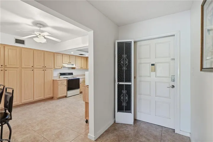 Entrance foyer featuring light tile patterned floors, ceiling fan, and a heating unit
