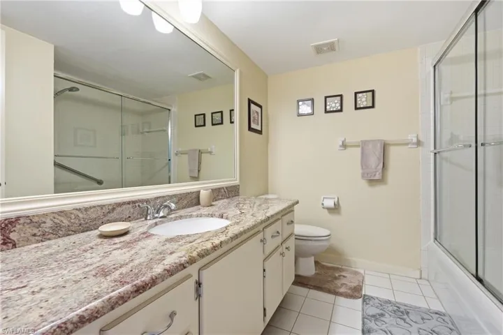 Full bath featuring light tile patterned floors and vanity