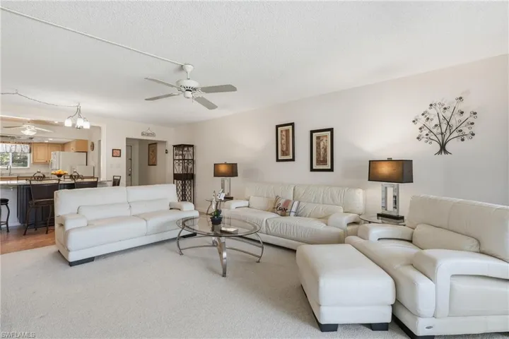 Living area with ceiling fan, a chandelier, and a textured ceiling