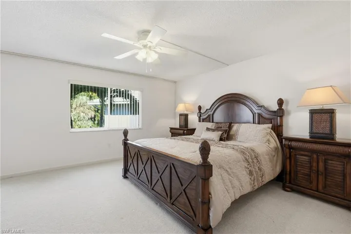 Bedroom with carpet flooring, a ceiling fan, and a textured ceiling