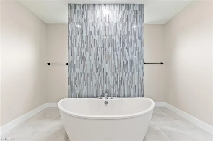 Bathroom featuring baseboards and a soaking tub