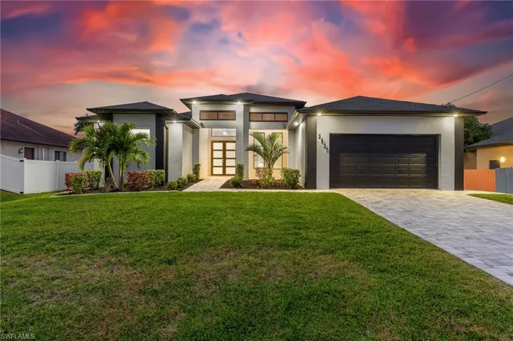 Prairie-style home with stucco siding, decorative driveway, and an attached garage