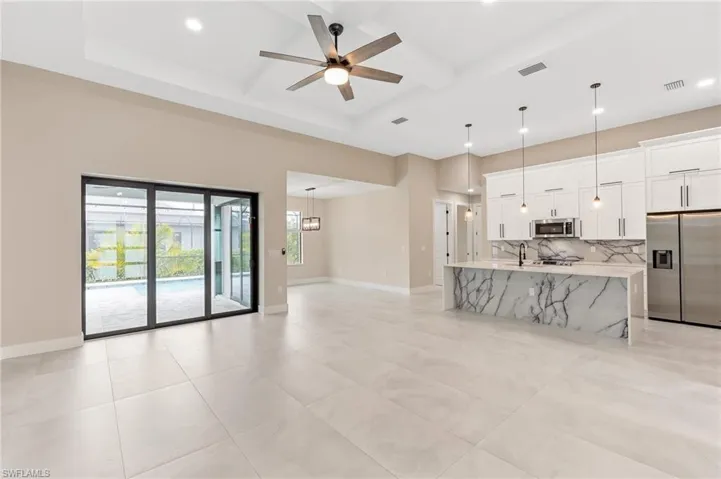 Living room featuring coffered ceiling, beam ceiling, ceiling fan, and recessed lighting