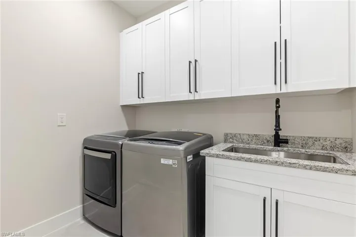 Laundry room featuring independent washer and dryer and cabinet space