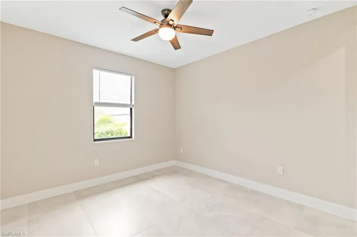 Unfurnished room featuring baseboards and ceiling fan