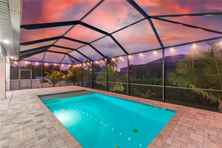 Swimming pool featuring glass enclosure, a sunroom, and a patio