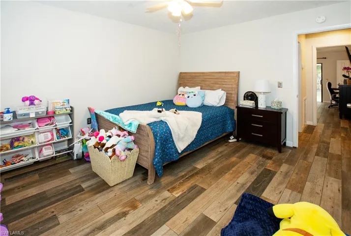 Bedroom with dark hardwood / wood-style floors and ceiling fan