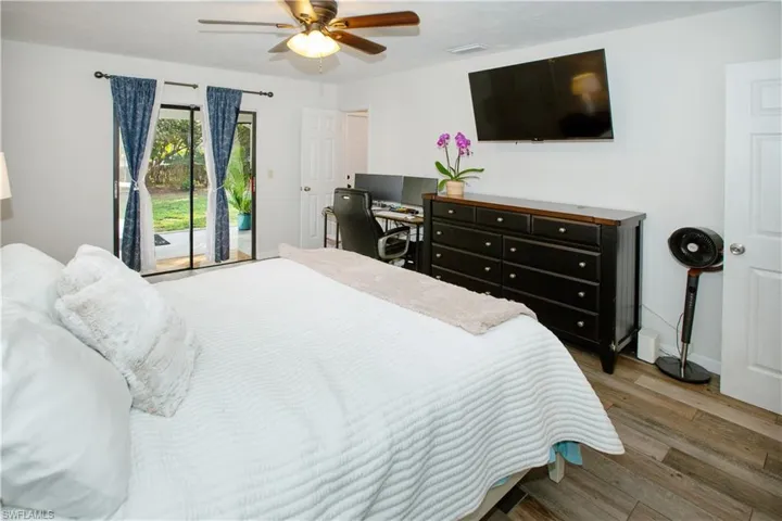 Bedroom with hardwood / wood-style flooring, access to outside, and ceiling fan