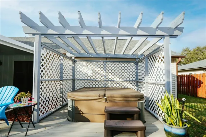 View of patio / terrace with a pergola, a hot tub, and a deck