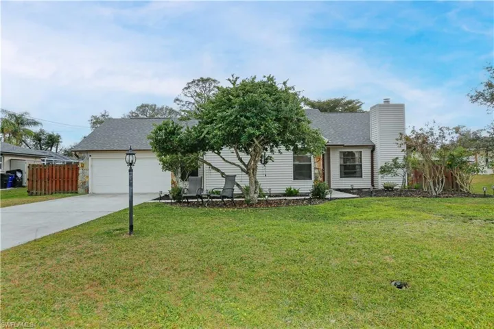 View of front facade featuring a garage and a front lawn