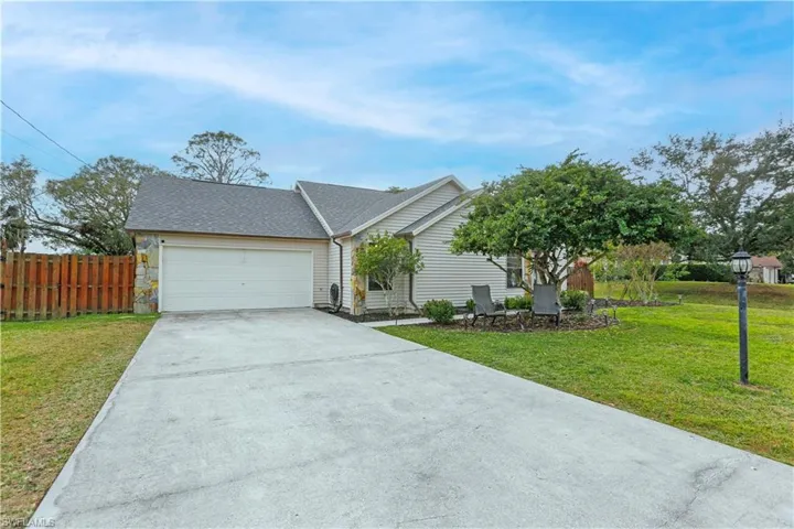 Ranch-style house featuring a garage and a front lawn