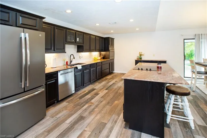 Kitchen featuring tasteful backsplash, stainless steel appliances, a center island, and light hardwood / wood-style floors