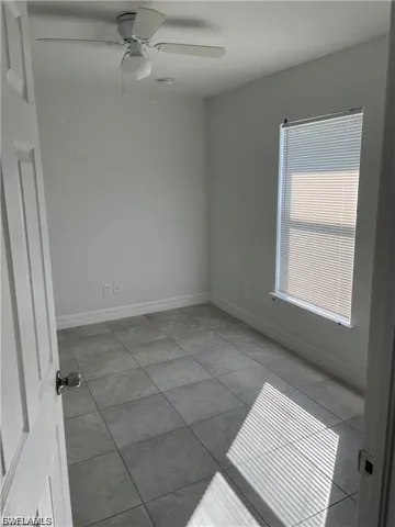 Spare room featuring a ceiling fan and light tile patterned floors