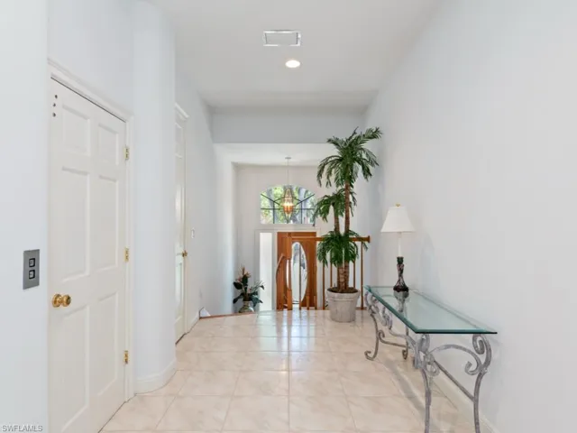 Hall with light tile patterned floors and recessed lighting