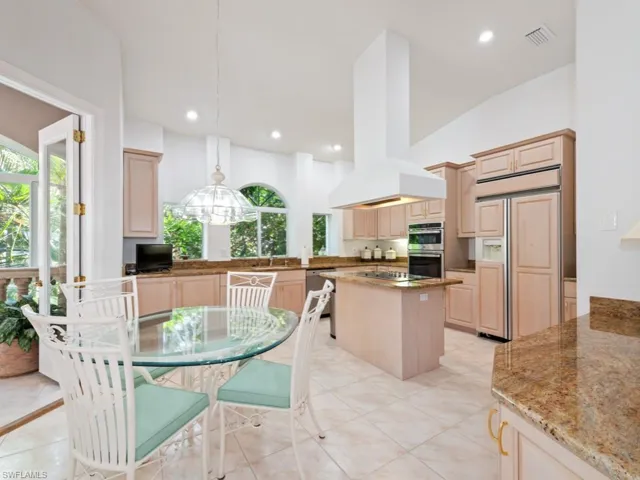 Dining room featuring plenty of natural light, recessed lighting, light tile patterned floors, and a towering ceiling