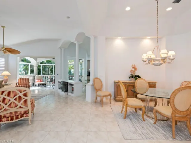 Dining area with decorative columns, recessed lighting, lofted ceiling, light tile patterned flooring, and a chandelier