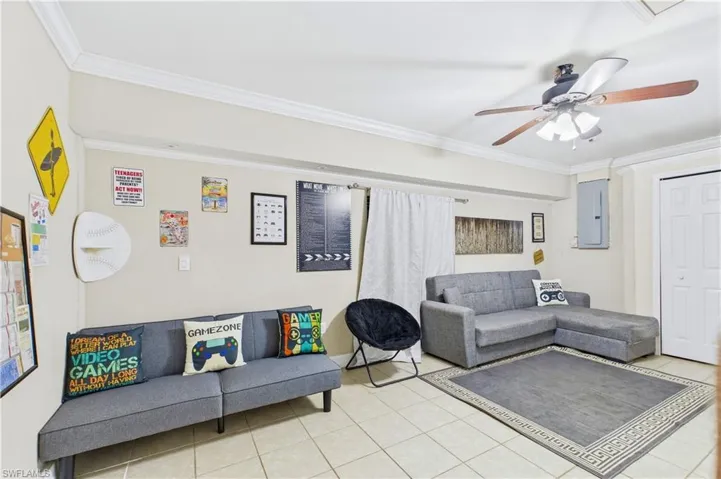 Flex room featuring neutral wall tones, crown molding, a ceiling fan with integrated lighting, tiled flooring, and a white bi-fold door