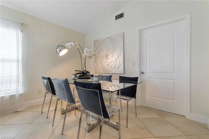 Dining space with vaulted ceiling and light tile patterned floors