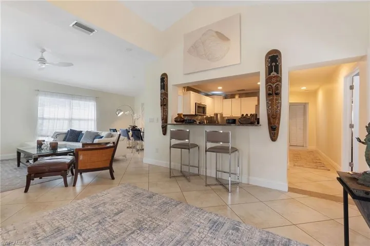 Living area featuring light tile patterned floors, a ceiling fan, high vaulted ceiling, and recessed lighting