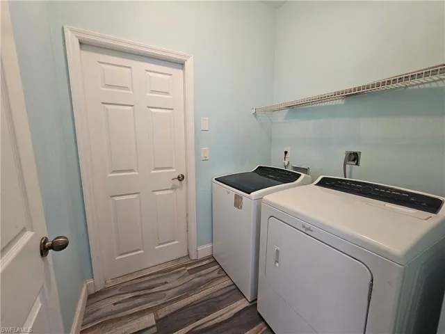 Laundry room with hookup for a washing machine, independent washer and dryer, dark hardwood / wood-style floors, and hookup for an electric dryer