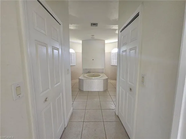 Hall featuring sink and light tile floors