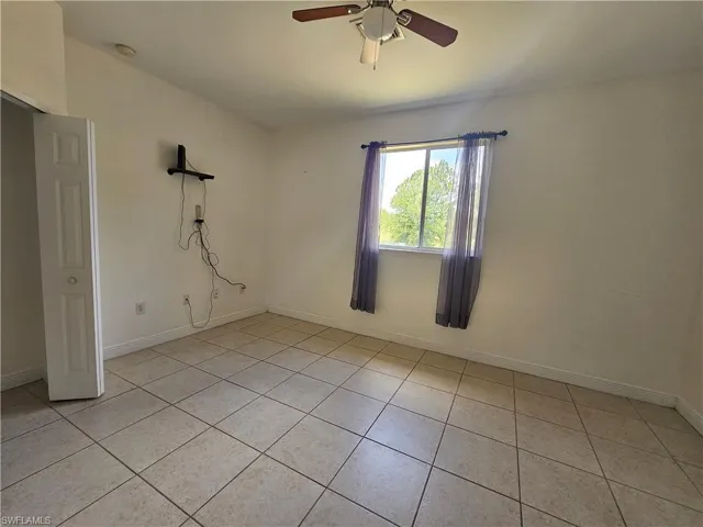 Unfurnished room featuring ceiling fan and light tile floors
