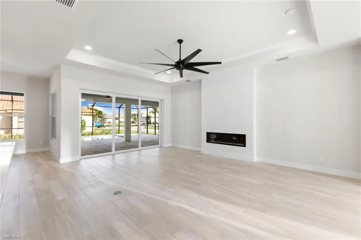 Views throug to the pool area and wood trimmed media wall with inset LED fire and electric pre fit for your large screen tv to be installed.