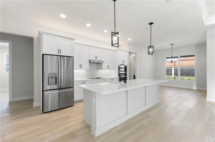 Stainless steel appliances, recessed lighting, quartz counters and island