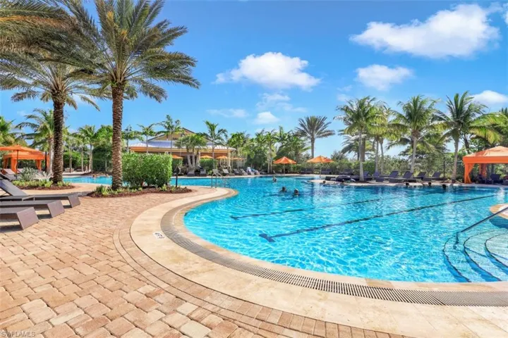 Resort pool with lap lanes, zero entry + sun umbrellas in shallow end.