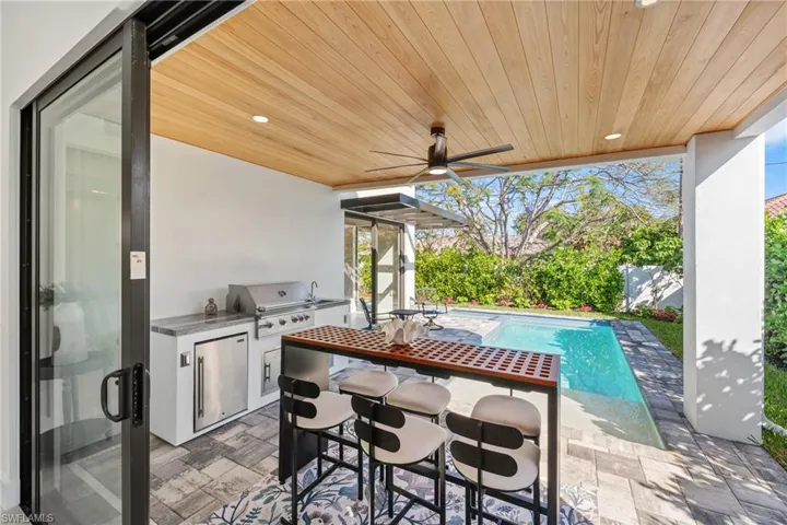 View of patio / terrace featuring an outdoor pool, ceiling fan, a grill, and an outdoor kitchen