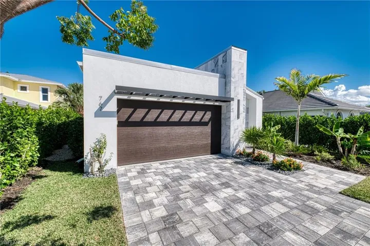 View of front of home featuring decorative driveway, an attached garage, and stucco siding