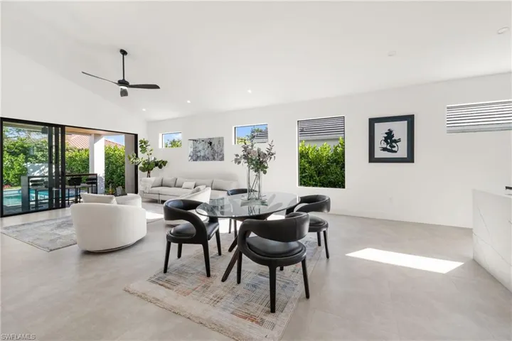 Dining space with baseboards, high vaulted ceiling, a ceiling fan, and recessed lighting