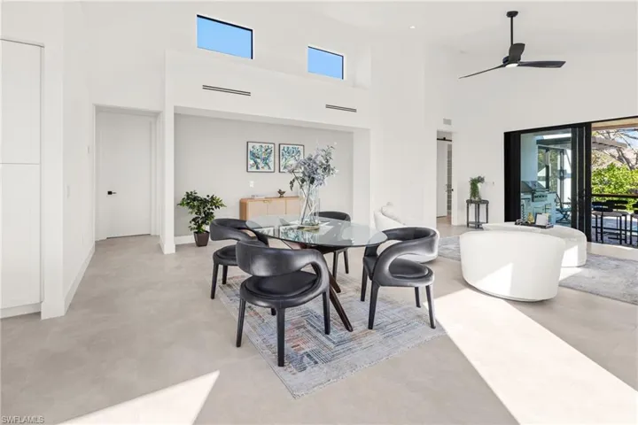 Dining area featuring ceiling fan, a high ceiling, and baseboards